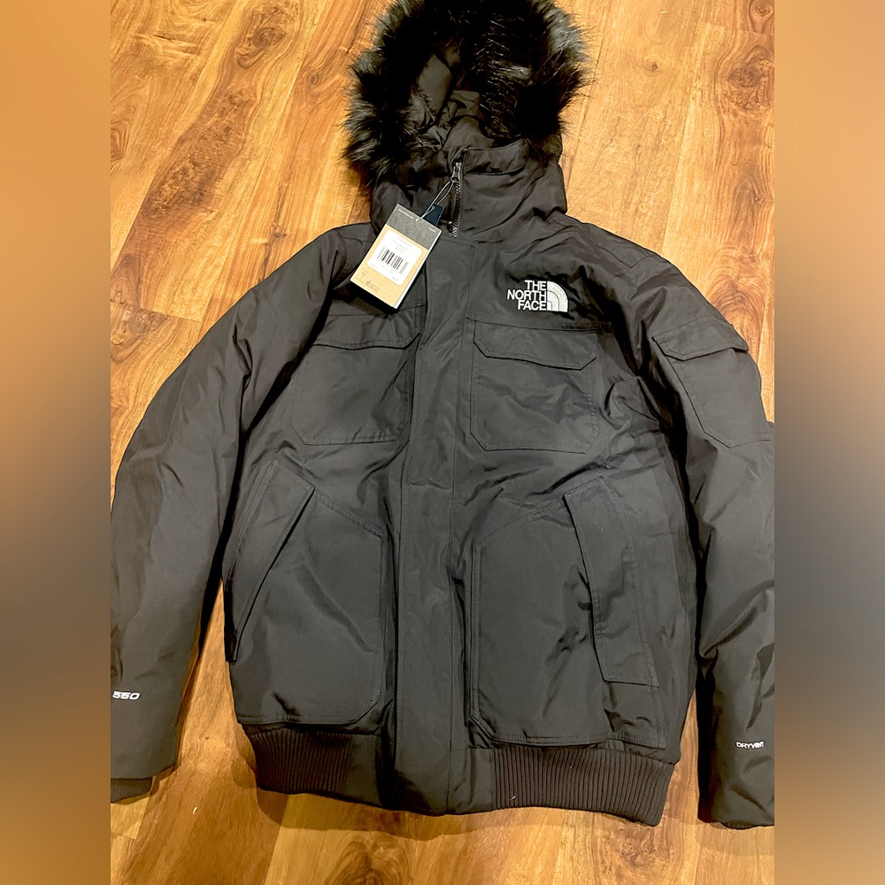 This is a North face jacket that is black and has a built in mouth covering